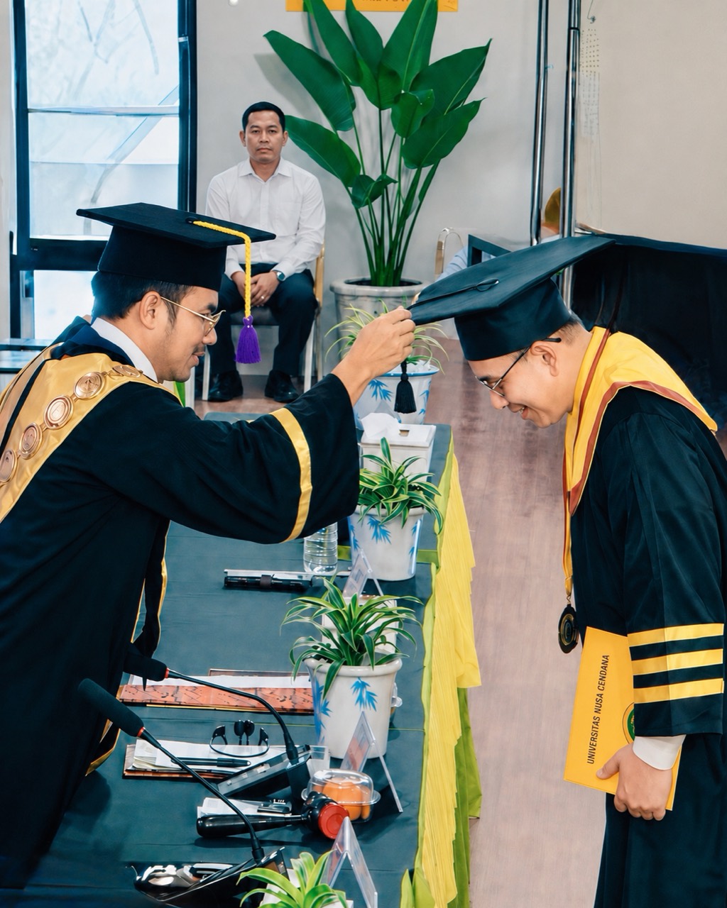 Reinheart menundukkan kepala saat prosesi wisuda di Universitas Nusa Cendana